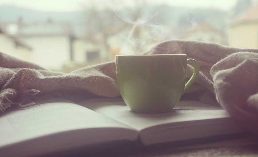 A cosy image of Coffee, a blanket and a book